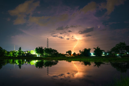 lightning in a rainstorm with high voltage pole at night