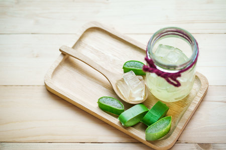 sliced and leaf of fresh aloe vera with aloe vera gel in glass on woodenの写真素材