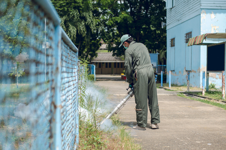 Man work fogging to eliminate mosquito for preventing spread dengue fever in the communityの写真素材
