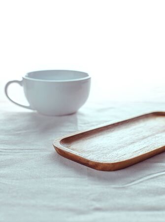 Empty wooden plate on the table and has a white backgroundの写真素材