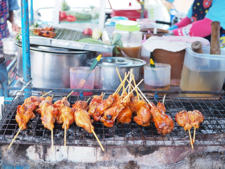 Grilled chicken in thailand.Hot Grilling chickens plugged with bamboo. smoked grill chicken barbecue, thai local food, traditional food Thailand. Rubber chicken on the grill Somtamの写真素材