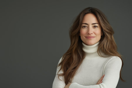 Portrait of a beautiful young woman with long hair on a gray backgroundの素材