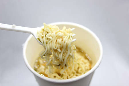 instant noodles, noodle soup in a cup, view from above. Instant noodles are sold in a precooked and...