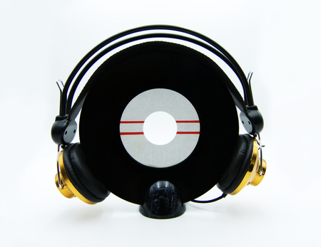 Vinyl single record with golden headphones on white backgroundの写真素材