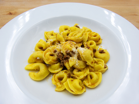 Tortellini with meat sauce (Tortellini with meat sauce) Traditional Italian pasta on wooden backgroundの写真素材