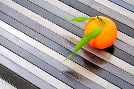 organic mandarine with green leaves, on striped backgroundの写真素材
