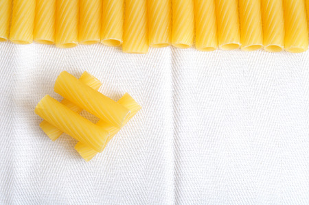 Hashtags Pasta, Itallian pasta background, with macaroni on white texile background, macaroni are...