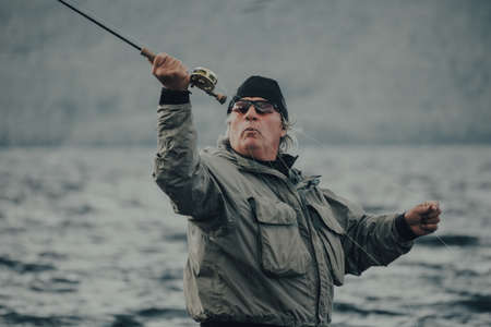 Fisherman immersed in the water of a lake with a fly rodの写真素材