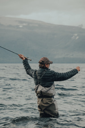 Fisherman looking for a good fly to fish in the lakeの写真素材