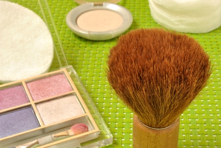 Various types of cosmetics, lipstick, face powder, eye shadow, a mirror and cotton ballsの写真素材