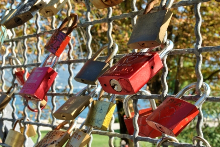 symbol of love padlocks attached to the bridge to the shore of Lake Gardaの写真素材