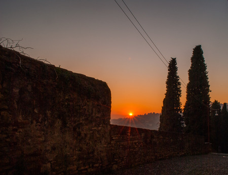 a beautiful orange sunset transforms the sky above Milanの写真素材