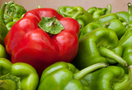 a basket with lots of green peppers with one red pepperの写真素材
