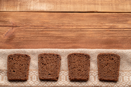 Four slices of rye bread on wooden table. Top view with space for your text.の写真素材