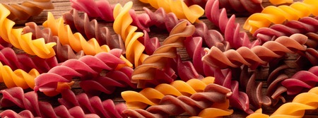 Colored Rotini Pasta on wooden table, top viewの写真素材