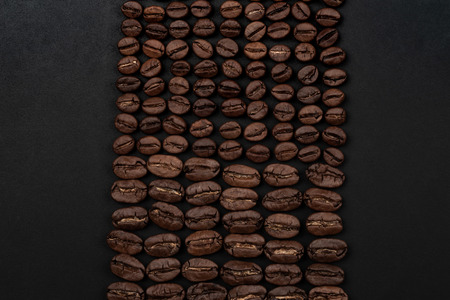 Roasted coffee beans on black background. Top view with space for your textの写真素材
