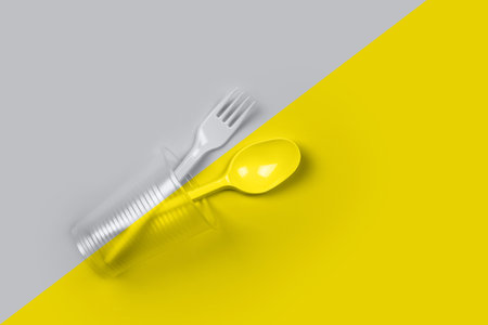 Plastic cup, fork, spoon on color 2021