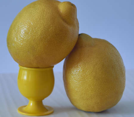 Several yellow sliced and whole lemons placed on a board with a light backgroundの写真素材