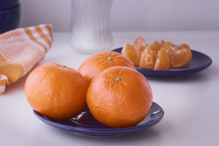 Orange clementines ready to be eaten. Orange fruit, fresh and natural. Fruit with or without sugar. Clementines in blue dishes.の写真素材