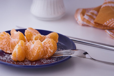 Orange clementines ready to be eaten. Orange fruit, fresh and natural. Fruit with or without sugar. Clementines in blue dishes.の写真素材