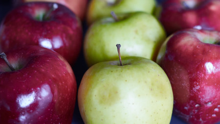 several bright red apples and green apples. close-up of red and green apples. red and green apples in a row.の写真素材