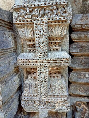 Stone pillar sculptured with beautiful design on the wall of templeの写真素材