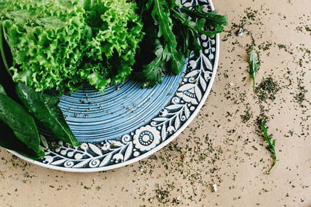 delicious fresh salad arugula spinach on amazing plate on craft background, top viewの写真素材