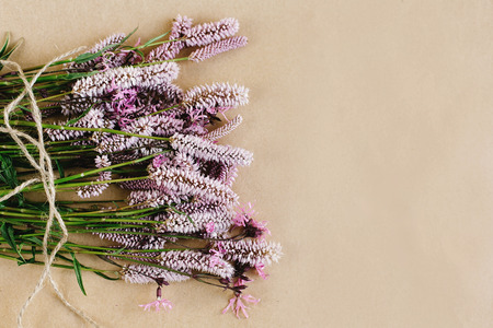 unusual beautiful violet and pink flowers on craft background, space for your text