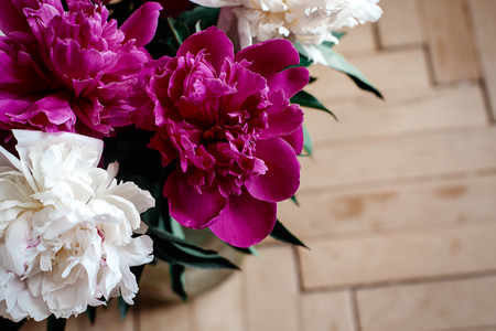 beautiful bunch of peonies in vase on wooden background, rustic wallpaper concept, space for textの写真素材