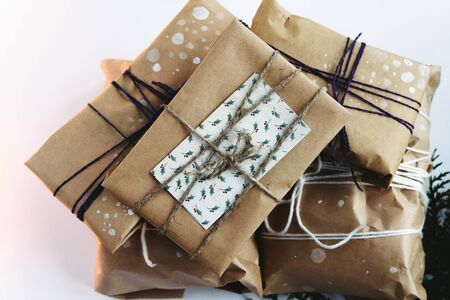 A pile of gift boxes in craft eco paper, handmade presents on white background. Greeting card conceptの写真素材