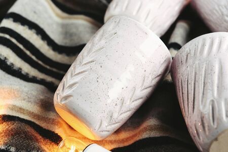 stylish creative ceramics cups and christmas garland lights, holiday celebration conceptの写真素材