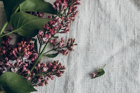 purple lilac flowers on rustic textile background on wooden table. space for text. top view.  spring...