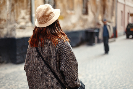 happy and stylish pretty hipster woman walking on background of old streets in european city, travel conceptの写真素材