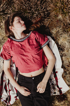 beautiful stylish woman hipster lying in grass and relaxing in sunny mountains,  summer travel...