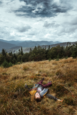 stylish beautiful traveling man hiking in the mountains on a background of a forestの写真素材