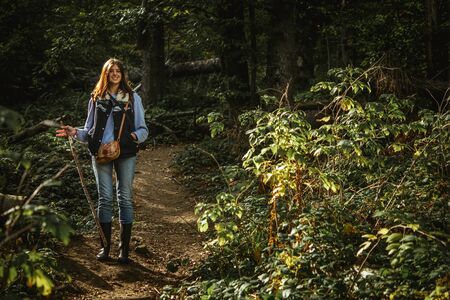 beautiful happy stylish traveling girl in the mountains on a background of a forestの写真素材