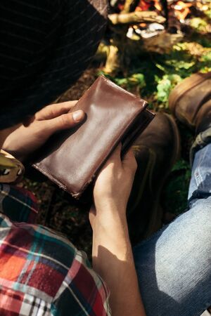 stylish hipster traveler holding tobacco and pipe in sunny forest in the mountains