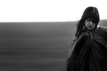 sad stylish girl standing in the windy evening outdoors in springfield, melancholy loneliness conceptの写真素材