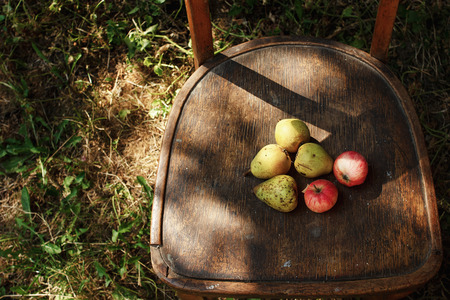 tasty fruits from garden  on rustic old wooden chair under soft sunlight, summer in the countryside, space for textの写真素材