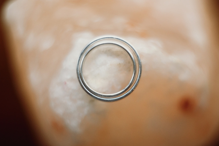 Closeup of couple silver wedding rings, two luxury golden engagement rings on white satin background, macro of expensive jewelleryの写真素材