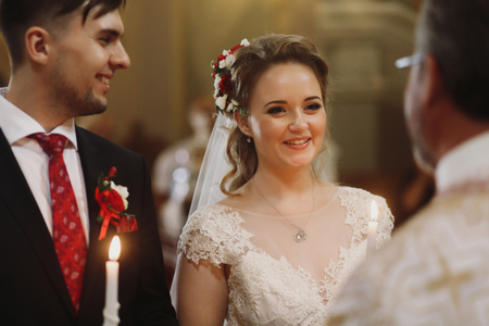 Spiritual couple, bride and groom holding candles during wedding ceremony in christian church, emotional moment during ceremony for man and womanの写真素材