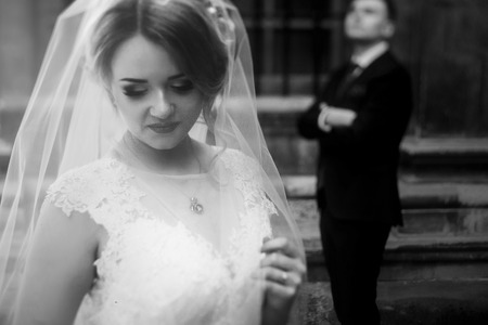 Beautiful blonde bride in luxury white wedding dress posing outdoors in italian street, face closeup...
