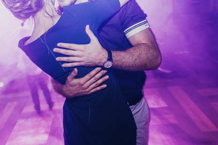 happy couple dancing at wedding party. man and woman hugging and embracing at luxury wedding reception. romantic joyful moments. light show. space for text.の写真素材