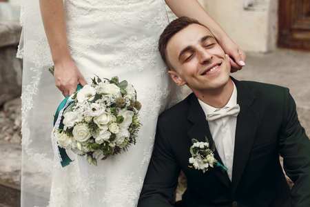 happy gorgeous bride caress and hugging happy stylish groom. emotional moment of beautiful wedding couple. true feelingsの写真素材
