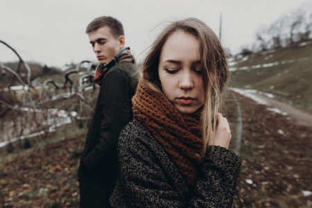 stylish hipster woman and man posing in windy autumn park. sensual atmospheric moment with space for text. fashionable cool couple creative photoの写真素材