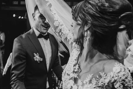 happy bride and stylish groom dancing at wedding reception. gorgeous wedding couple having fun and partying in restaurant. newlywed emotional moment. space for text. black whiteの写真素材