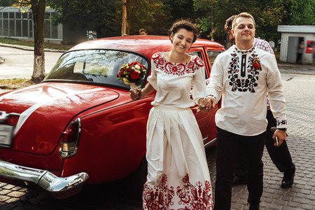 stylish bride and happy groom near car on the background of restaurantの写真素材