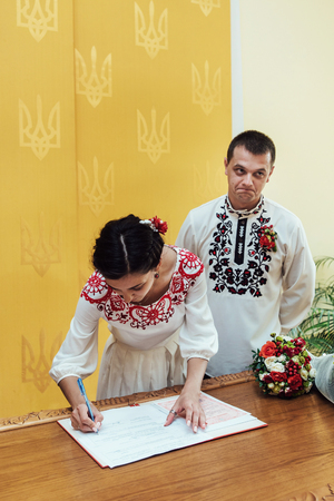 stylish bride and groom, signing official wedding registerの写真素材