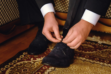 stylish elegant groom getting dressed in the morning for a weddingの写真素材
