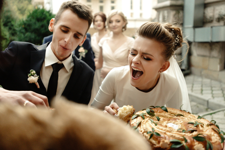 happy bride and groom tasting cake and laughing, funny moment, true emotions, gorgeous weddingの写真素材